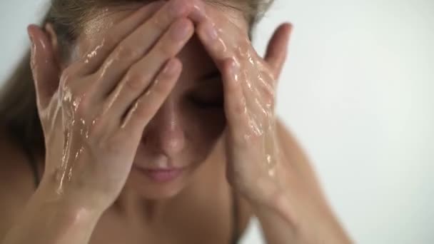 Een jong mooi meisje wast haar gezicht. Gezichtsverzorging. — Stockvideo