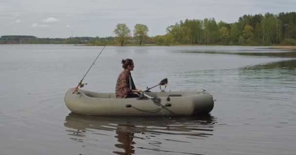 美しい映画撮影だ。湖の上に女の子漁師漕ぎオアーズインフレータブルボート. — ストック動画