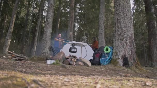 Ein Liebespaar baut ein Zelt auf und wirft ein Vordach über das Zelt. — Stockvideo