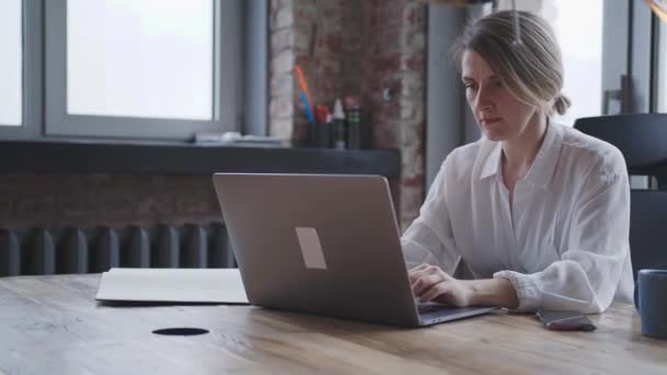 Junge Frau arbeitet für einen Laptop im Büro für die geschäftliche Korrespondenz. — Stockvideo