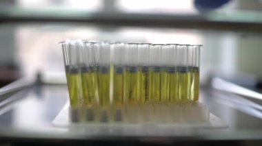 Kimya laboratuarındaki tezgahta sarı bir tıbbi hazırlık şişesi var.