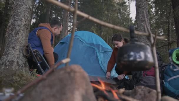 Pár zamilovaných turistů si postaví stan v lese. Samota v přírodě. — Stock video