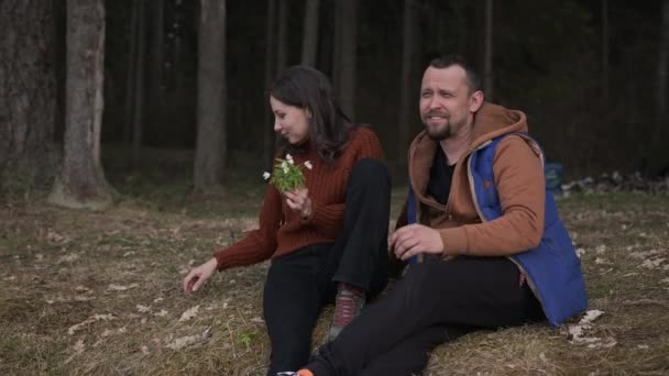Ett par älskare sitter i skogen i ett campingläger och pratar. — Stockvideo