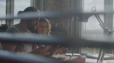 Arkadaşlar ortak bir projede birlikte çalışıyorlar, gülümsüyorlar ve gülüyorlar..