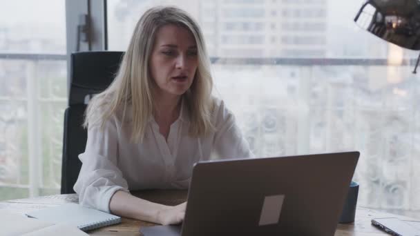 Ofiste dizüstü bilgisayarda çalışan genç bir kadın iş yazışmaları yapıyor.. — Stok video