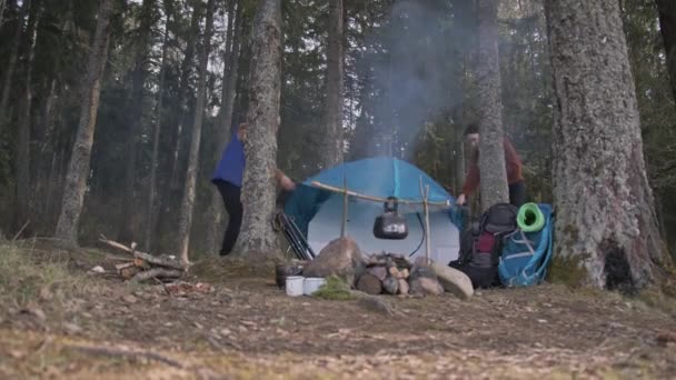 Ein Liebespaar baut ein Zelt auf und wirft ein Vordach über das Zelt. — Stockvideo