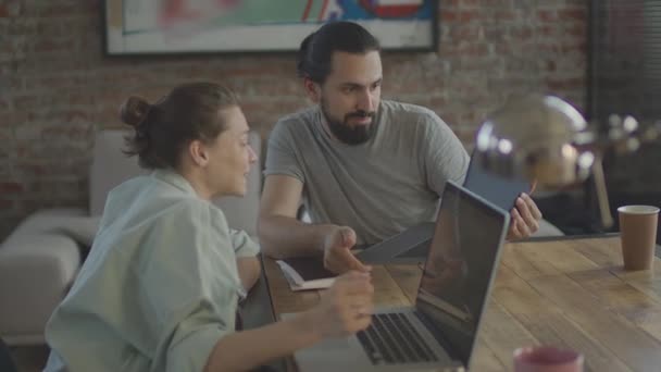 Los amigos están trabajando juntos en un proyecto común, sonriendo y riendo. — Vídeos de Stock