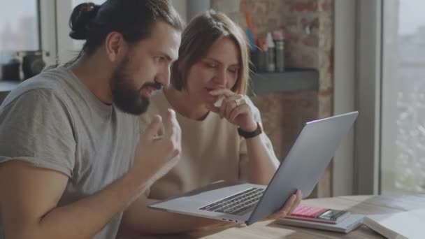 Los amigos están trabajando juntos en un proyecto común, sonriendo y riendo. — Vídeos de Stock