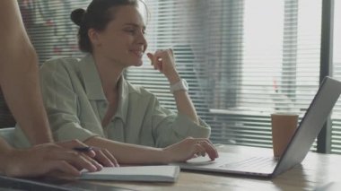 Arkadaşlar ortak bir projede birlikte çalışıyorlar, gülümsüyorlar ve gülüyorlar..