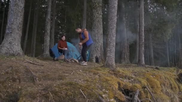 Een prachtige filmische opname van twee jonge toeristen, een man en een vrouw in hout. — Stockvideo