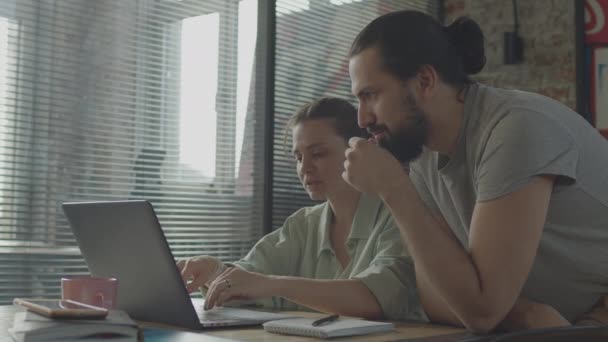 Los amigos están trabajando juntos en un proyecto común, sonriendo y riendo. — Vídeo de stock