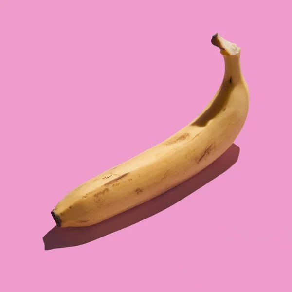 Renkli, olgun, pembe arka planda soyulmuş muz. Desen konsepti.