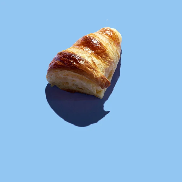 Küçük bir arkaplanda kruvasan kesimi. Üst görünüm, düz görünüm, modern asgari resim kavramı