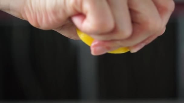 Θηλυκό Χέρι Που Πιέζει Μισό Λεμόνι Σκούρο Φόντο Κλείσε — Αρχείο Βίντεο