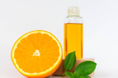 Ceset için portakal yağı. Beyaz arka planda ahşap bir kaidede turuncu. Bitkisel içerikli organik SPA kozmetik ürünleri. Kozmetoloji. 