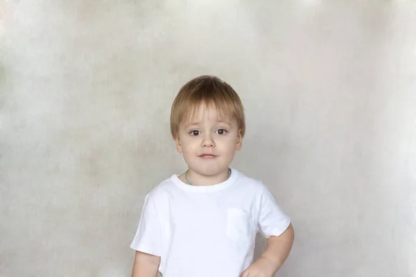 白いTシャツにかわいい男の子の肖像画 子供の感情 壁の背景に子供 明るいアイデア 創造的なアイデアやコンセプト 広告バナーの概念 — ストック写真