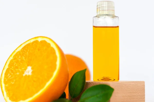 Ceset için portakal yağı. Beyaz arka planda ahşap bir kaidede turuncu. Bitkisel içerikli organik SPA kozmetik ürünleri. Kozmetoloji.