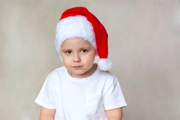 Portret Uroczego Chłopca Białej Koszulce Kapeluszu Świętego Mikołaja Emocje Dzieci — Zdjęcie stockowe