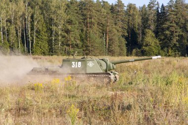 Moskova, Rusya, 2018-08-25, askeri teçhizat sergisi, askeri teçhizat gösterisi. Yeşil ağaçların arka planında hareket eden bir askeri tank. Tank 
