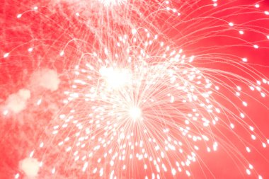 Havai fişekler. Karanlık gökyüzünde parlak, kırmızı havai fişekler. Gecenin havai fişekleri gökyüzünü pembeye çevirdi..