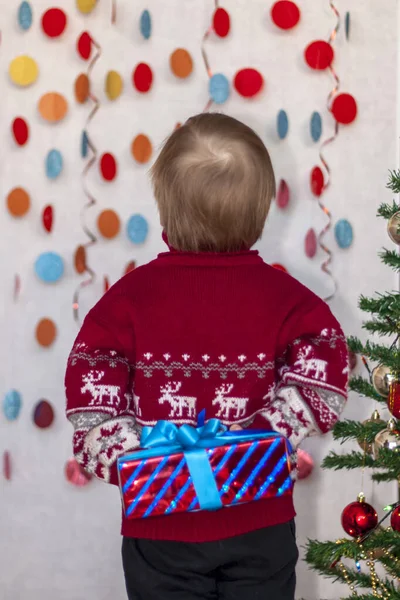 一个手里拿着礼物的孩子背着它孩子们的感情圣诞节和新年 广告横幅的概念 — 图库照片