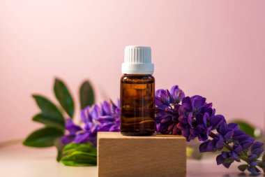 Kürsüde yağlı etiketsiz bir şişe. Bej-pembe arka planında şeker kutusu olan şeffaf cam bir kap. Ürün afişi. Metin ve tasarım için boşluk. Kozmetoloji ve güzellik kavramı 