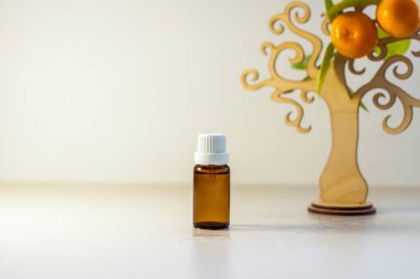 Mandalina yağlı etiketsiz bir şişe. Şeffaf cam bir şişe kahverengi renk. Doğal bir kozmetik ürünü. Ürün afişi. Metin ve tasarım için bir yer. Kozmetoloji ve güzellik kavramı