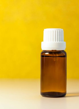 Kozmetik yağlı etiketsiz bir şişe. Şeffaf cam bir şişe kahverengi renk. Doğal bir kozmetik ürünü. Ürün afişi. Metin ve tasarım için bir yer. Kozmetoloji ve güzellik kavramı