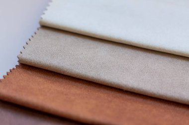 Bej bir arka planda tekstil, mobilya ve giysi dekorasyonu için doğal ve yapay kumaşlardan yapılmış arka planlar. Mobilya üretimi. Metni kopyalamak için alanı olan duvar kağıdı. Doku