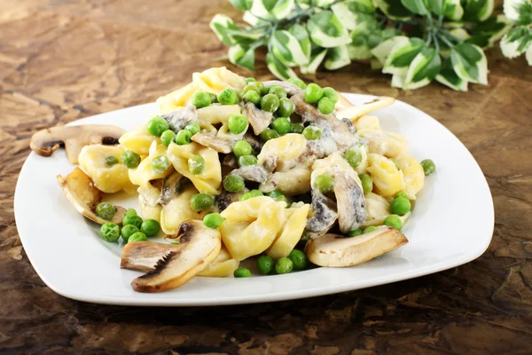 Tortellini à la crème, champignons et pois — Photo