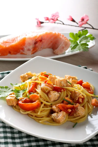 Pasta con salmón fresco, tomate y cebollino Imagen de stock