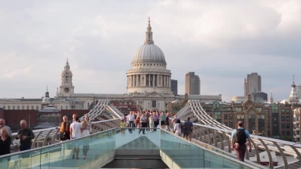 Millennium bridge with people walking and St Paul cathedral in a summer evening in London — Stock Video