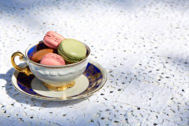 Mavi ve altın süslemeli seramik bardaklı makarna bisküvileri