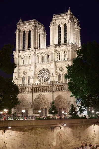 Facciata di Notre Dame di notte con persone a Parigi — Foto Stock