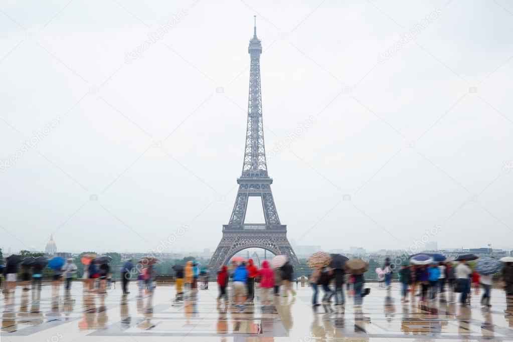 Eiffel tower in Paris with tourists and rain