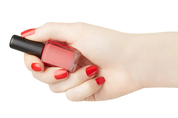 Weibliche Hand mit roter Nagellackflasche — Stockfoto