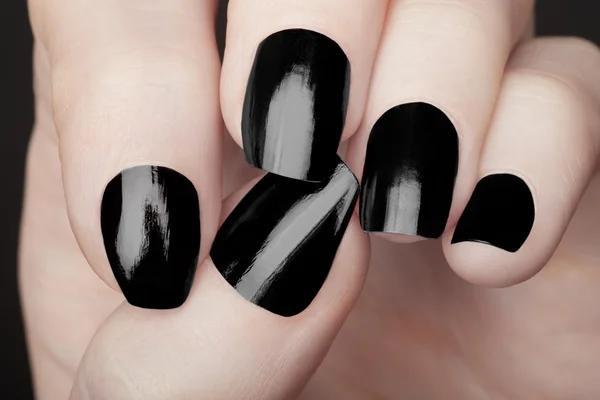 Manicura en mano femenina con esmalte de uñas negro —  Fotos de Stock
