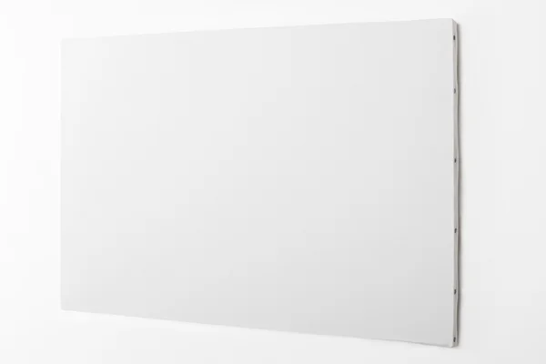 白い壁に白い空白のキャンバス — ストック写真