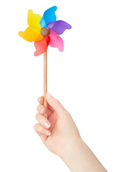 Mulher mão segurando pinwheel colorido no branco — Fotografia de Stock