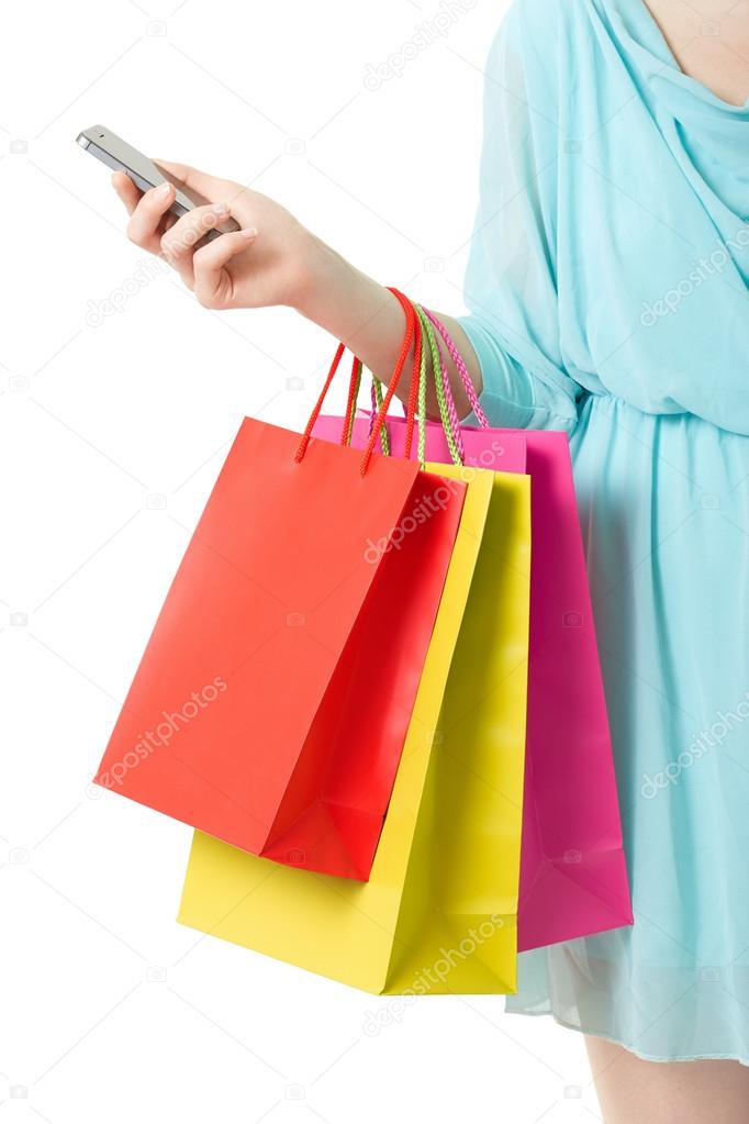 Woman hand holding shopping bags and smartphone