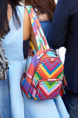Woman poses for photographers with colorful backpack, Milan fashion week