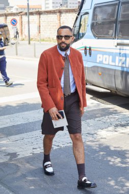 MILAN, İtalya - 22 Haziran 2025: Turuncu ceketli ve kahverengi şortlu Jean Claude Mpassy Prada defilesinden önce, Milan Moda Haftası tarzı