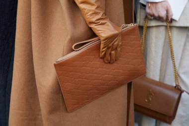 MILAN, İtalya - 27 Şubat 2025: Kahverengi deri çantalı ve eldivenli kadın Max Mara moda defilesinden önce, Milan Moda Haftası tarzı