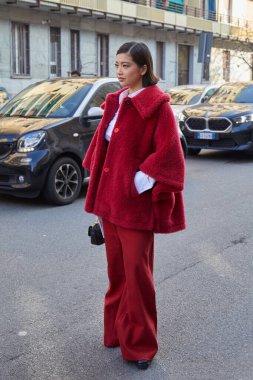 MILAN, İTALYA - 27 Şubat 2025: kırmızı kürklü ve pantolonlu kadın Max Mara moda defilesinden önce, Milan Moda Haftası tarzı
