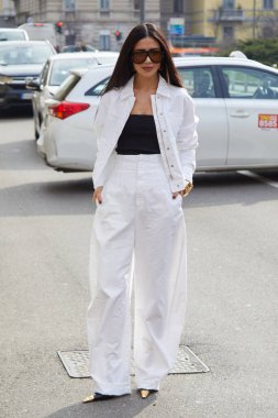 MILAN, İTALYA - 28 Şubat 2025: Beyaz ceketli, geniş pantolonlu ve siyah kolsuz bluzlu kadın Sportmax defilesinden önce, Milan Moda Haftası tarzı