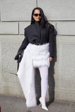 MİLAN, İTALYA - 28 Şubat 2025: Siyah ceketli, beyaz kürklü ve yüksek topuklu ayakkabılı kadın Sportmax defilesinden önce, Milan Moda Haftası tarzı