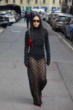 MILAN, İtalya - 28 Şubat 2025: Yuwei Zhangzou, Sportmax defilesinden önce transparan alt ve kırmızı çantalı siyah elbiseli, Milan Moda Haftası tarzı