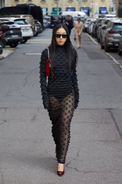 MILAN, İtalya - 28 Şubat 2025: Yuwei Zhangzou, Sportmax defilesinden önce transparan alt ve kırmızı çantalı siyah elbiseli, Milan Moda Haftası tarzı