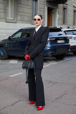 MİLAN, İTALYA - 28 Şubat 2025: Siyah takım elbiseli, kırmızı eldivenli ve ayakkabılı kadın Sportmax defilesinden önce, Milan Moda Haftası tarzı