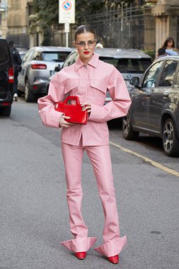 MİLAN, İTALYA - 28 Şubat 2025: Pembe deri ceketli, pantolonlu, kırmızı çantalı ve spor maksimum moda defilesinden önce ayakkabılı kadın, Milan Moda Haftası tarzı